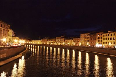 Canal amidst illuminated buildings against sky at night