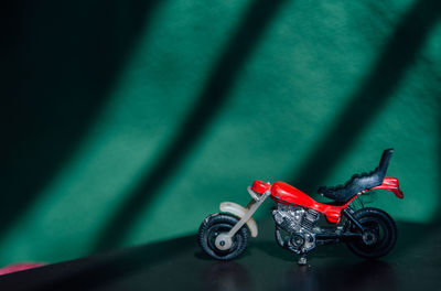 A fresh red motorbike behind a green background