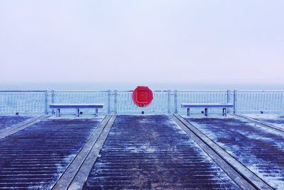 Red umbrella by sea against sky