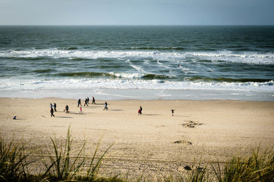 People at beach against clear sky