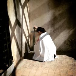 Rear view of woman standing against wall