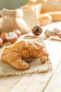 Close-up of croissant and ingredients on table