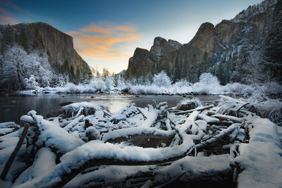 Scenic view of snow covered mountains against sky during sunset