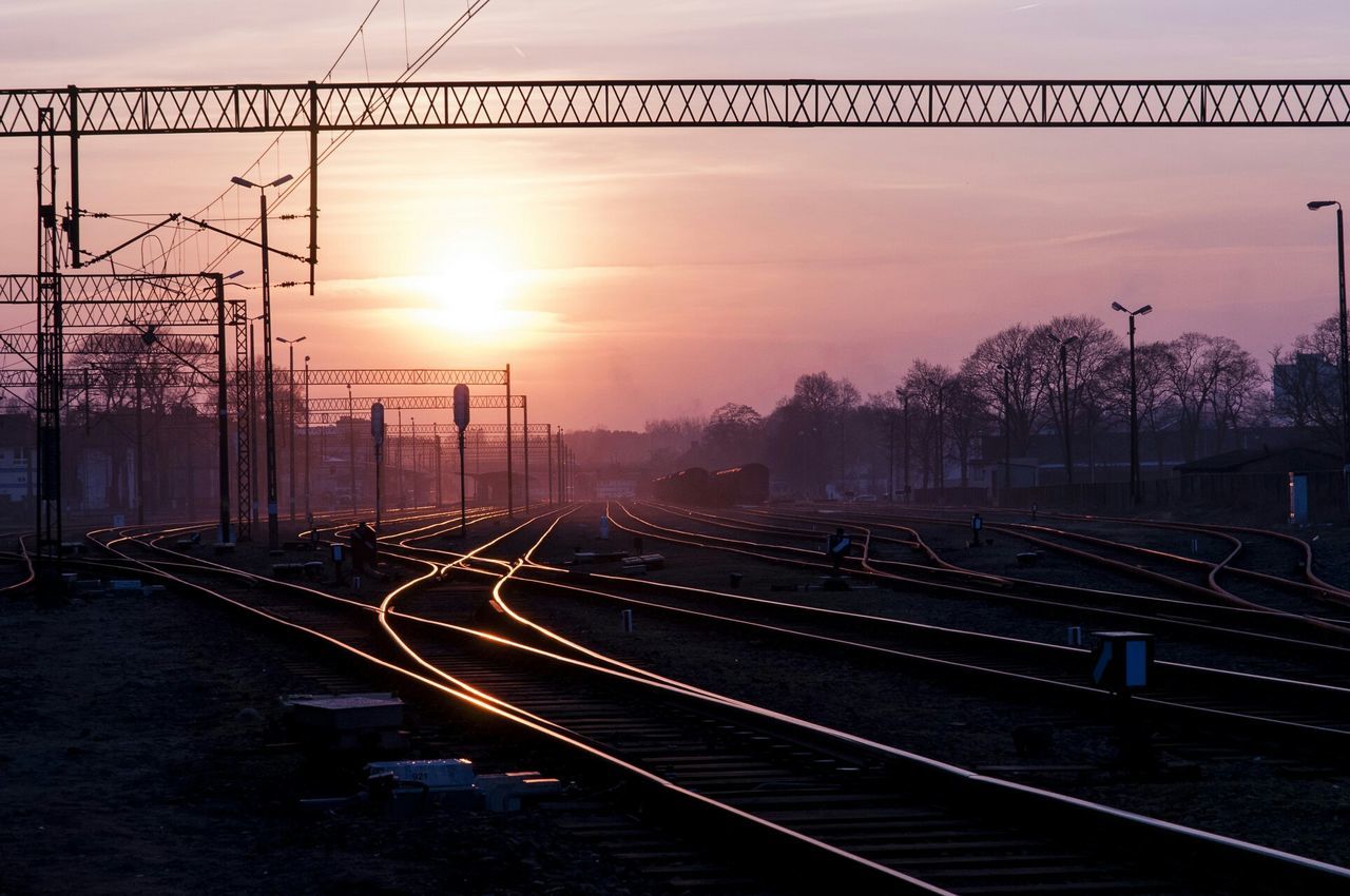 sunset, railroad track, connection, transportation, rail transportation, sky, orange color, the way forward, sun, electricity pylon, diminishing perspective, bridge - man made structure, long, sunlight, metal, silhouette, built structure, vanishing point, outdoors, bridge