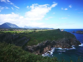 Scenic view of sea and mountains against sky