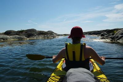 Rear view of man sitting in kayak