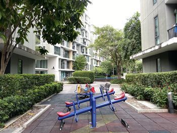 People on bench by building in city