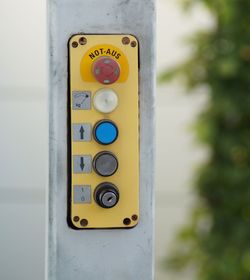 Close-up of information sign on pole against wall