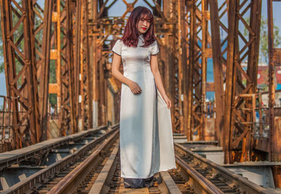 Portrait of woman standing on railroad tracks