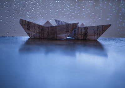 Close-up of paper flag on table against blue background