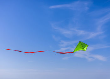 Low angle view of kite flying against blue sky