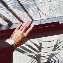 Cropped hand of woman holding window sill