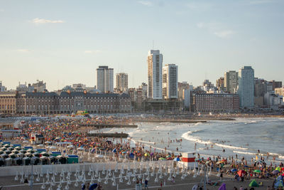 High angle view of people on beach against buildings in city