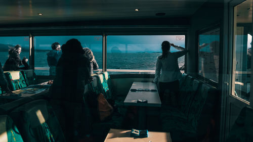 People standing by window at railroad station