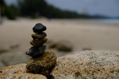 Close-up of stone stack on rock at beach