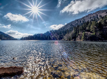 Scenic view of lake by mountains against sky