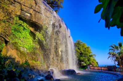 Scenic view of waterfall against sky