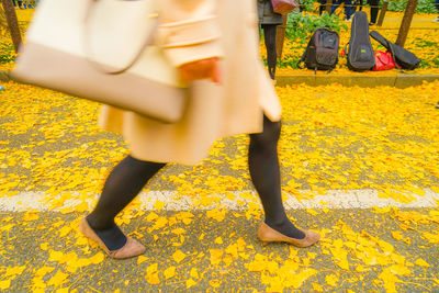 Low section of woman walking on road