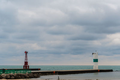 Lighthouse by sea against sky