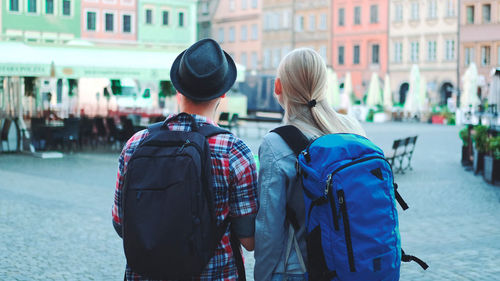 Rear view of people walking on street in city