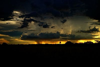 Silhouette of landscape against cloudy sky