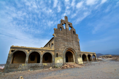 Low angle view of historical building against cloudy sky