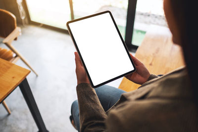 Midsection of woman using digital tablet