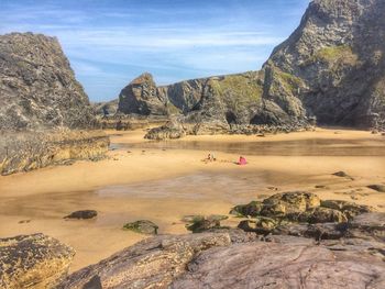 Scenic view of beach and rock formations against sky