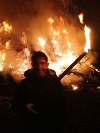 Close-up of man with fire crackers at night