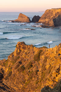 Woman on a cliff at praia de odeceixe in costa vicentina, portugal