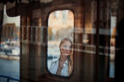 Young woman reflecting on mirror in boat