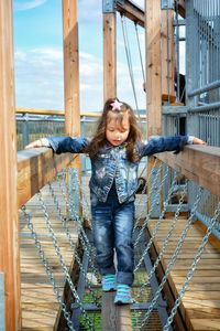 Full length of happy girl standing on footbridge