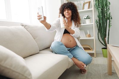 Young woman sitting on sofa at home