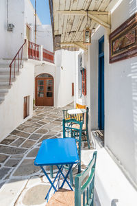 Empty chairs and tables against building