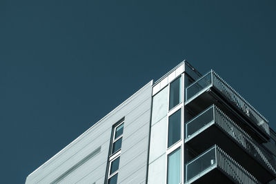 Low angle view of modern building against clear blue sky