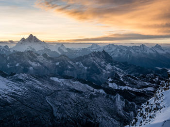 Scenic view of snowcapped mountains against sky during sunset
