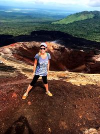 Portrait of young woman wearing sunglasses while standing on mountain