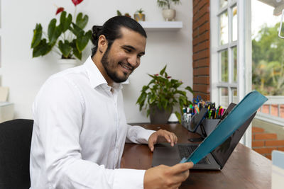 Young man using mobile phone at home