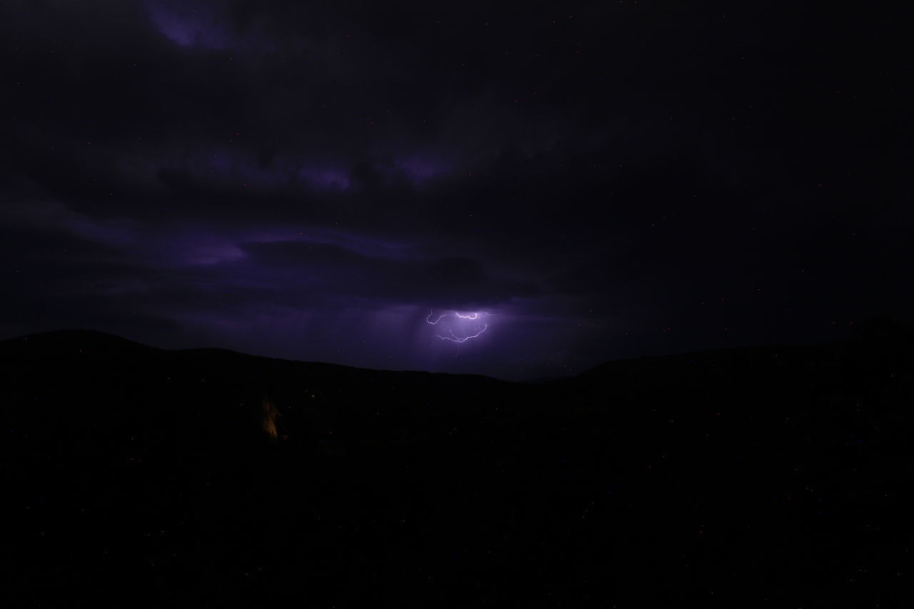 sky, night, beauty in nature, darkness, cloud, scenics - nature, mountain, environment, lightning, power in nature, nature, dark, no people, storm, dramatic sky, silhouette, thunderstorm, star, landscape, tranquility, outdoors, astronomy, tranquil scene, thunder, awe, space, moonlight