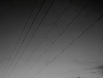 Low angle view of power lines against sky