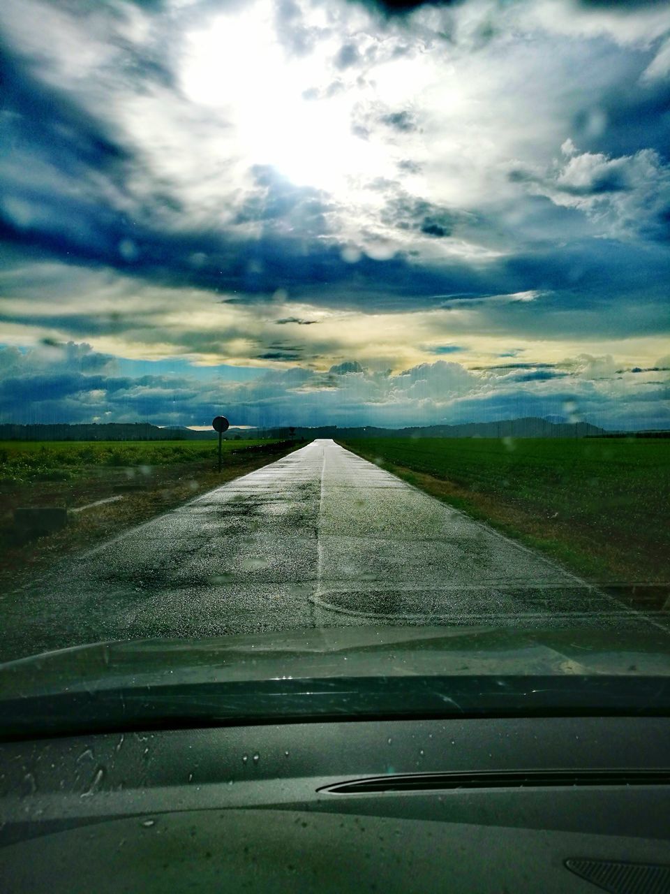 ROAD AGAINST SKY SEEN FROM CAR WINDSHIELD