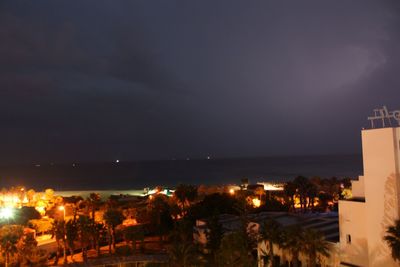 Illuminated cityscape against sky at night