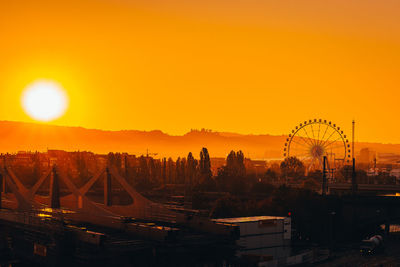 Amusement park against sky during sunset