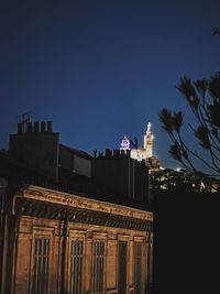 Low angle view of building against clear sky at night