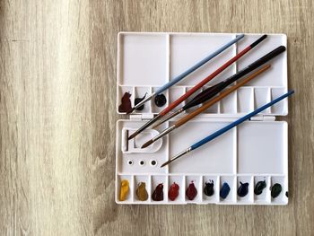 Paintbrushes and watercolors paint on table