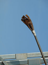 Low angle view of hand against clear sky