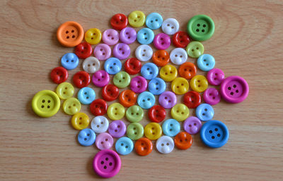 High angle view of multi colored buttons on table