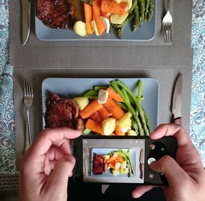 Close-up of photographing cut vegetables on table