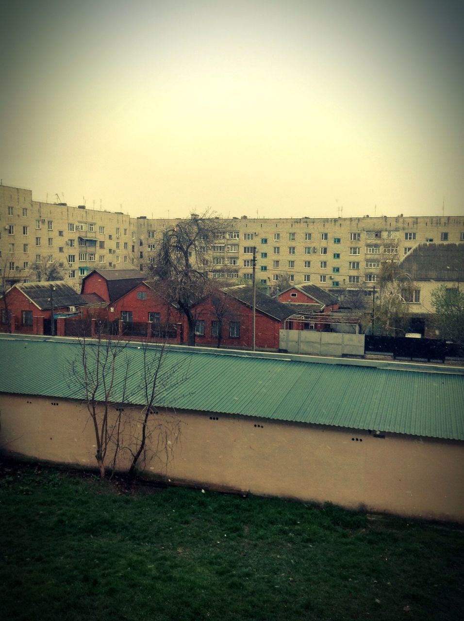 building exterior, architecture, built structure, clear sky, house, residential structure, copy space, residential building, city, sky, residential district, outdoors, day, building, no people, grass, auto post production filter, sunlight, cityscape, field