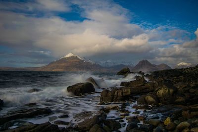 Scenic view of sea and mountains against sky